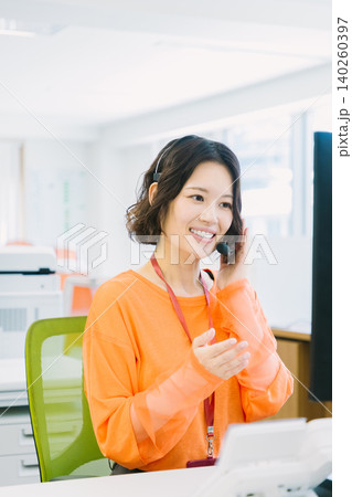 オフィスでヘッドセットをつけて応対する女性オペレーター オフィスでヘッドセットをつけて応対する女性オペレーター 140260397