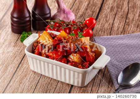 Hearty Beef Stew with Potatoes and Red Peppers in Ceramic Dish 140260730