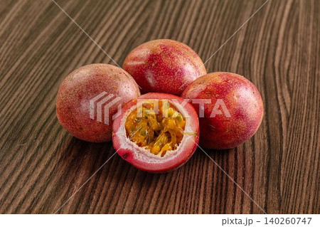 Fresh passion fruit on wooden table with cut half showing pulp 140260747