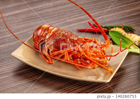 Red Spiny Lobster on Beige Plate with Chili Peppers and Ginger 140260753
