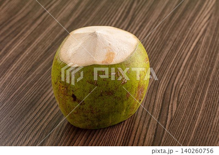 Fresh green coconut with cut top on wooden table Fresh green coconut with cut top on wooden table 140260756