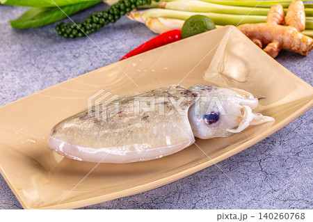 Raw squid on beige plate with fresh herbs and spices 140260768