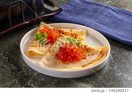 Traditional pancakes with red caviar and parsley on white plate Traditional pancakes with red caviar and parsley on white plate 140260817