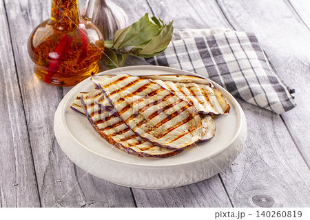 Grilled eggplant slices on ceramic plate with olive oil and bay leaves Grilled eggplant slices on ceramic plate with olive oil and bay leaves 140260819