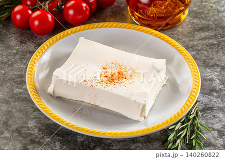 Block of white feta cheese with paprika on plate with tomatoes and olive oil Block of white feta cheese with paprika on plate with tomatoes and olive oil 140260822