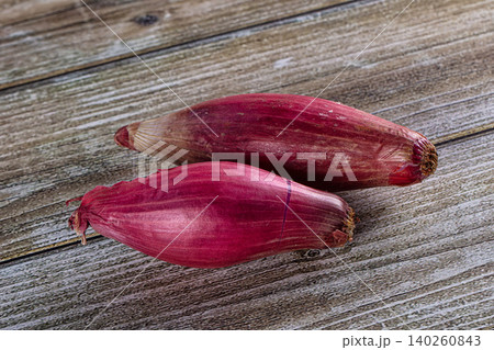 Two fresh red banana blossoms on rustic wooden background Two fresh red banana blossoms on rustic wooden background 140260843