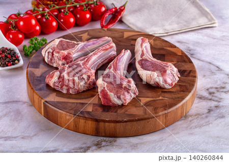 Raw lamb chops with tomatoes and spices on wooden board Raw lamb chops with tomatoes and spices on wooden board 140260844