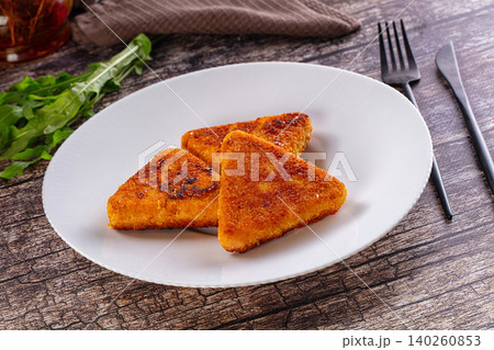 Fried triangular cheese snacks with arugula on white plate Fried triangular cheese snacks with arugula on white plate 140260853