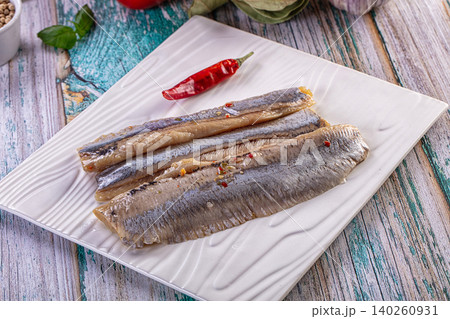 Marinated herring fillets with red chili pepper on white plate Marinated herring fillets with red chili pepper on white plate 140260931