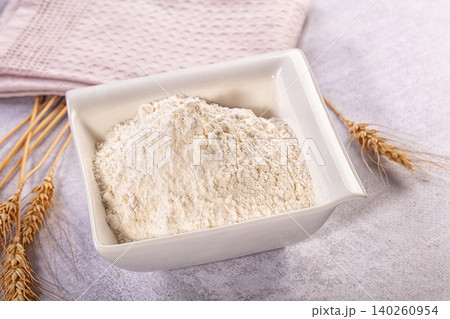 White flour in square bowl with wheat stalks and pink cloth White flour in square bowl with wheat stalks and pink cloth 140260954