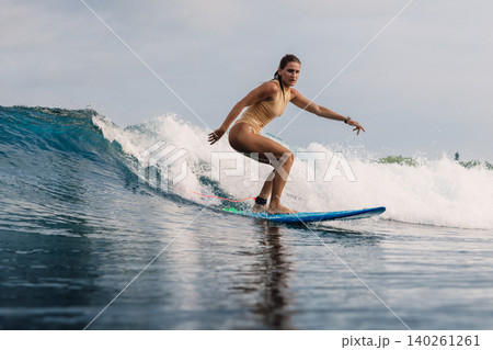 Female surfer on surfboard during surfing. Surfer woman on ocean wave Female surfer on surfboard during surfing. Surfer woman on ocean wave 140261261