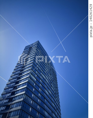 Modern glass skyscraper rising into a clear blue sky Modern glass skyscraper rising into a clear blue sky 140261429