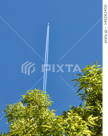 Airplane leaving twin contrails in a clear blue sky Airplane leaving twin contrails in a clear blue sky 140261450