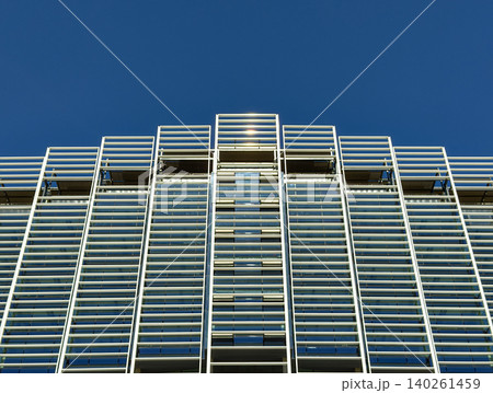 Modern building facade with blue metal louvers against a clear sky Modern building facade with blue metal louvers against a clear sky 140261459