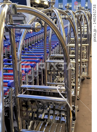 A row of metal luggage carts at an airport or hotel A row of metal luggage carts at an airport or hotel 140261738