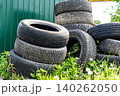 A Collection of Stacked Used Car Tires Surrounded by Green Grass 140262050