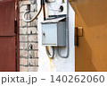 A Weathered Electrical Box Mounted on a Wall with Various Cables and Pipes in an Urban Setting, Highlighting Industrial Design and Textures 140262060