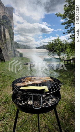 Close up view of barbecue smoking on a sunny day at a picnic by the river 140262084