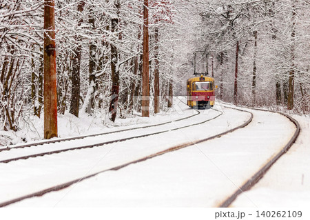 An old tram moving through a winter forest 140262109