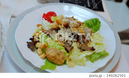 Crispy romaine lettuce topped with grilled chicken, golden croutons, shaved parmesan, and pine nuts, dressed in classic caesar vinaigrette Crispy romaine lettuce topped with grilled chicken, golden croutons, shaved parmesan, and pine nuts, dressed in classic caesar vinaigrette 140262501