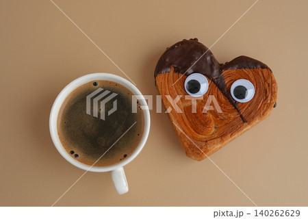 Coffee with Funny food game face with crazy eyes April fool day joke Delightful and vibrant heartshaped pastry croissant treat, beautifully topped with colorful frosting galore. Food experimentation Coffee with Funny food game face with crazy eyes April fool day joke Delightful and vibrant heartshaped pastry croissant treat, beautifully topped with colorful frosting galore. Food experimentation 140262629