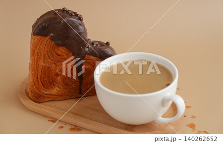 Latte cappuccino coffee drink with Delicious fresh croissant topped with Dark chocolate flavor Ganache. Creation unique heart shape bakery. Puff pastry holiday love gift present idea Valentine's day 140262652