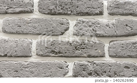 Gray brick wall texture in close-up with rough surface and white mortar joints. 140262690