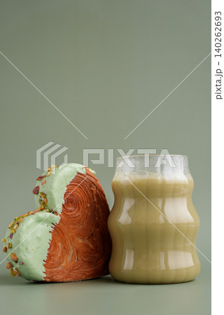 Green tea Matcha latte cappuccino beverage Morning breakfast gift idea Heart shaped pistachio croissant on green background with copy space. Puff pastry trendy sweet dessert bakery. Creamy dough 140262693