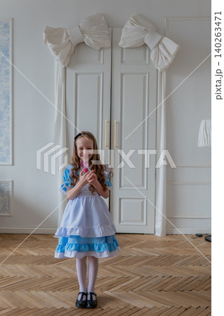 Poised White Girl In Blue Dress Speaking While Standing Before Decorative White Doors, Holding Lollipop, Ruffled Sleeves, Lace Apron, Polished Parquet, Attentive Expression, Soft Daylight, Formal Yet Poised White Girl In Blue Dress Speaking While Standing Before Decorative White Doors, Holding Lollipop, Ruffled Sleeves, Lace Apron, Polished Parquet, Attentive Expression, Soft Daylight, Formal Yet 140263471