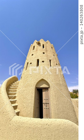 Ancient Tower Silhouette. Historic Spiraled Adobe Structure. Weathered Mud Tower With Spiral Staircase. Old Architectural Tower Featuring Winding Staircase And Shadow Play 140263808