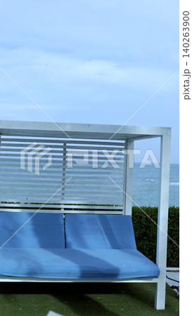 Serene Outdoor Setting. Charming Patio With Cushions. Relaxing Seating Area Beneath Cloudy Sky. Modern Outdoor Lounge With Lush Greenery And Comfortable Cushions Serene Outdoor Setting. Charming Patio With Cushions. Relaxing Seating Area Beneath Cloudy Sky. Modern Outdoor Lounge With Lush Greenery And Comfortable Cushions 140263900