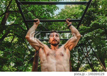 Man Doing Pull Up Training In Nature Man Doing Pull Up Training In Nature 140264129