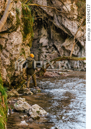 Male Hiker Crossing Forest River Male Hiker Crossing Forest River 140264217