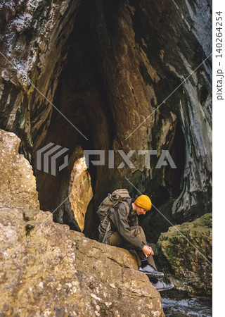 Hiker Tying Shoelaces inside Limestone Cave Hiker Tying Shoelaces inside Limestone Cave 140264254