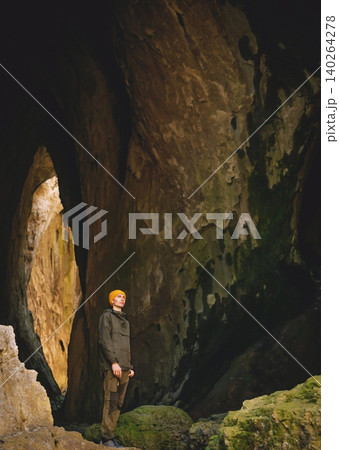 Man Hiker Standing in Natural Limestone Cave Man Hiker Standing in Natural Limestone Cave 140264278