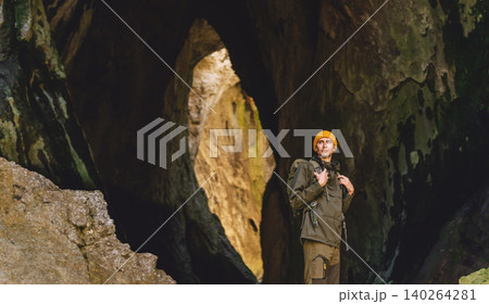 Male Traveler with Tourist Backpack Standing inside Cave 140264281