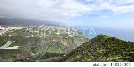 Aerial view of terraced agricultural fields on a hillside with winding roads and patches of green vegetation in a mountainous region. High quality photo Aerial view of terraced agricultural fields on a hillside with winding roads and patches of green vegetation in a mountainous region. High quality photo 140264306