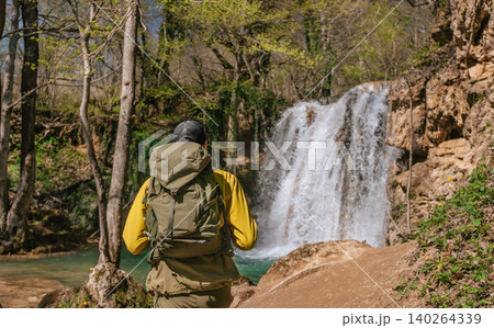Male Hiker with Tourist Backpack by Forest Waterfall 140264339