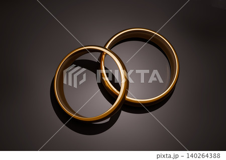 Two gold wedding rings on dark luxury background, elegant bridal jewelry concept Two gold wedding rings on dark luxury background, elegant bridal jewelry concept 140264388