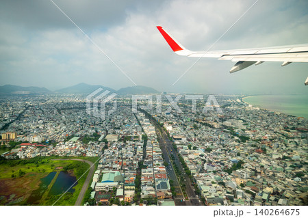 Plane takes off over city of Da Nang in Vietnam, aerial view from inside of cabin porthole at city Plane takes off over city of Da Nang in Vietnam, aerial view from inside of cabin porthole at city 140264675
