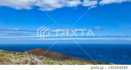 Scenic coastal landscape featuring a volcanic cone, lush greenery, and a clear blue sky over the ocean horizon with gentle waves and distant clouds. High quality photo Scenic coastal landscape featuring a volcanic cone, lush greenery, and a clear blue sky over the ocean horizon with gentle waves and distant clouds. High quality photo 140264688