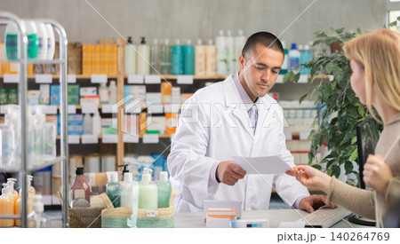 Young male pharmacist serving girl holding prescription in drugstore Young male pharmacist serving girl holding prescription in drugstore 140264769