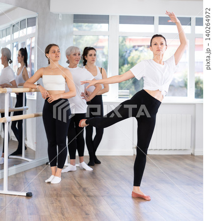 Female ballet instructor demonstrating movements to group in studio 140264972