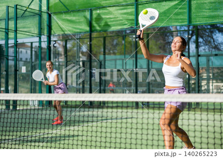 Padel game - woman with partners plays on tennis court Padel game - woman with partners plays on tennis court 140265223