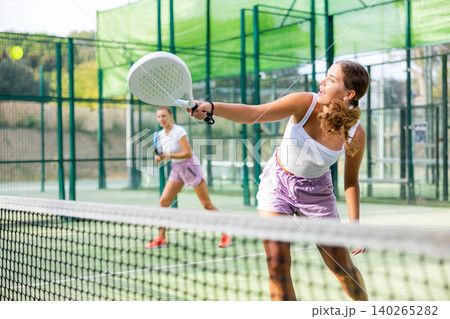 Young woman padel tennis player trains on the outdoor court 140265282