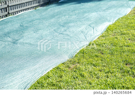 Summer grass lawn preparations in city parks, young turf grass safely growing under protective cover Summer grass lawn preparations in city parks, young turf grass safely growing under protective cover 140265684