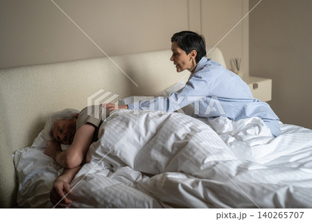 Exhausted senior woman trying to wake up sleeping husband at night and stop loud disturbing snoring. Exhausted senior woman trying to wake up sleeping husband at night and stop loud disturbing snoring. 140265707