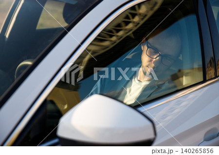 Tired business man falling asleep sitting inside her car seen through windshield 140265856