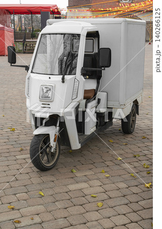 Electric delivery vehicle parked in a busy plaza Electric delivery vehicle parked in a busy plaza 140266125