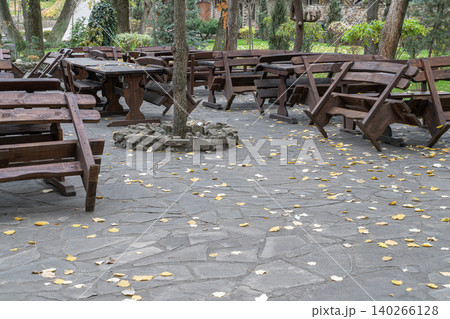 Outdoor seating area with wooden tables and chairs Outdoor seating area with wooden tables and chairs 140266128